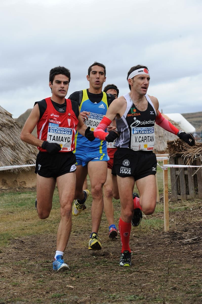 Atletas corriendo una prueba de cross por un circuito de tierra