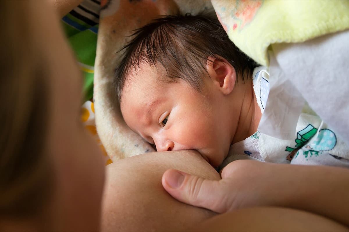 Una madre da el pecho a su bebé recién nacido